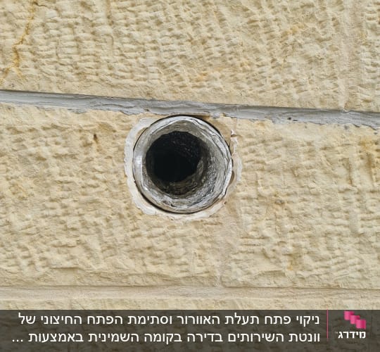 חור עגול בקיר אבן עם צינור מתכת